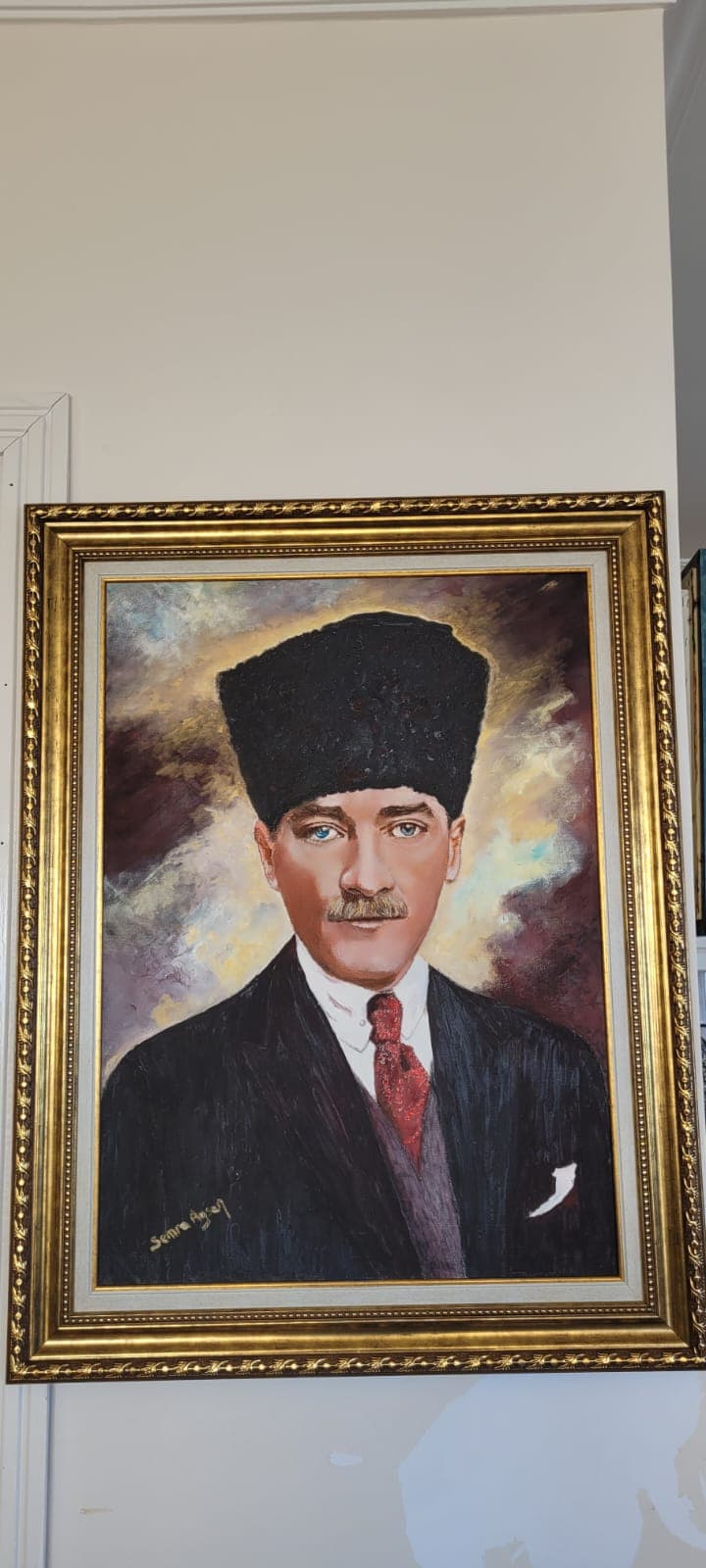 Ölgemälde von Mustafa Kemal Atatürk mit schwarzem Kalpak, Anzug und roter Krawatte in goldenem Rahmen.